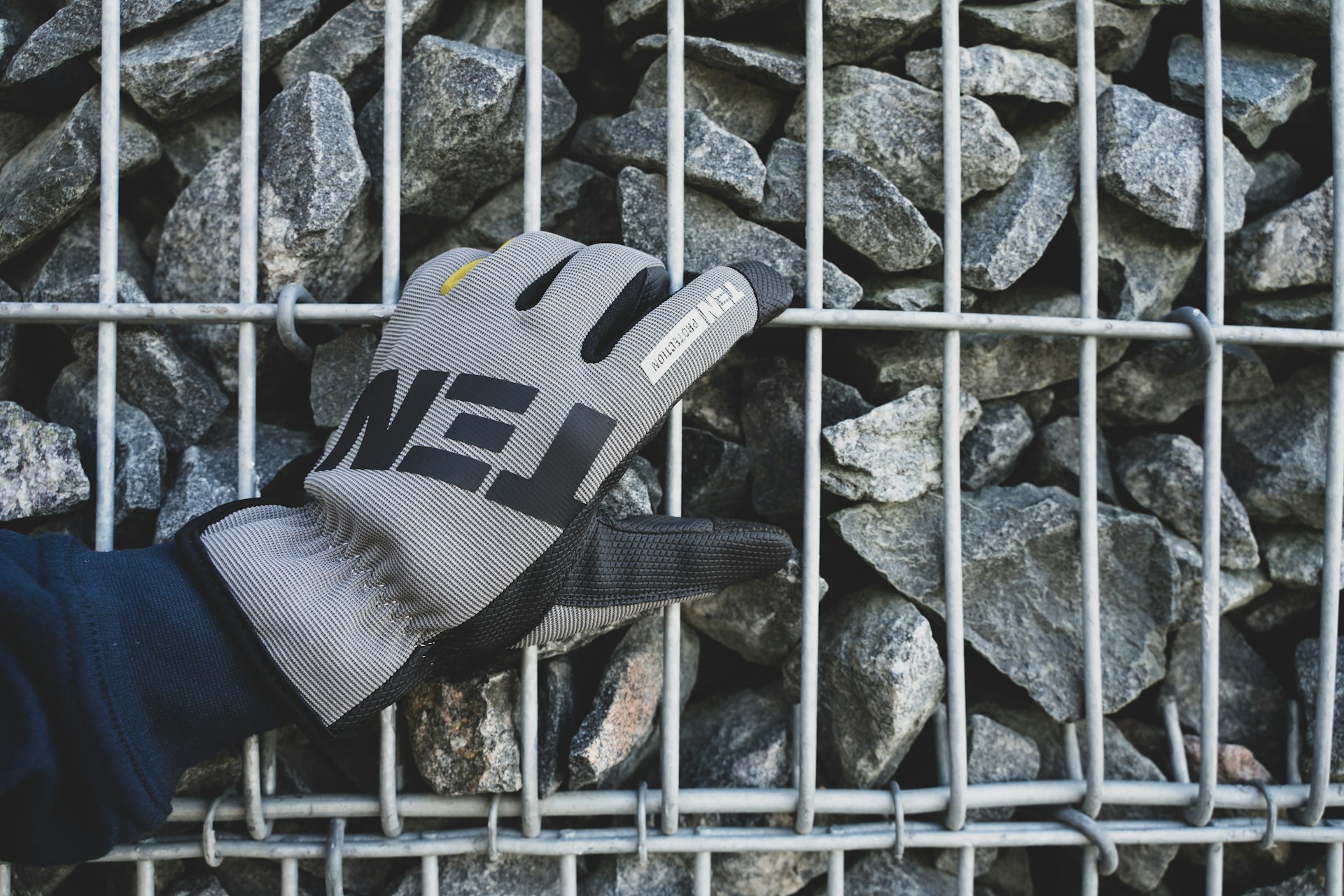 a person holding a glove over a pile of rocks